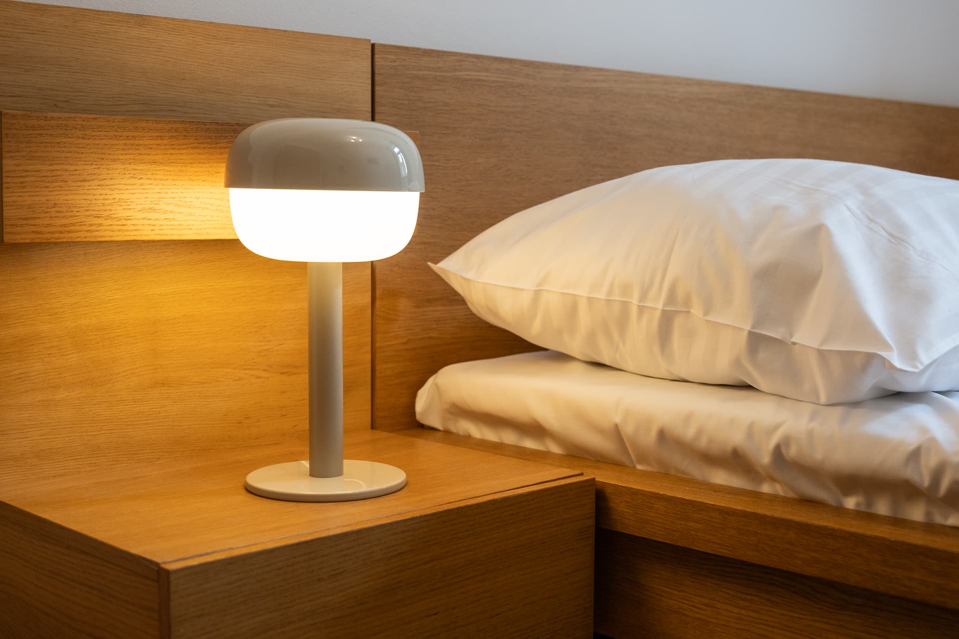 Warm bedside lamp and crisp bedding at Letna71